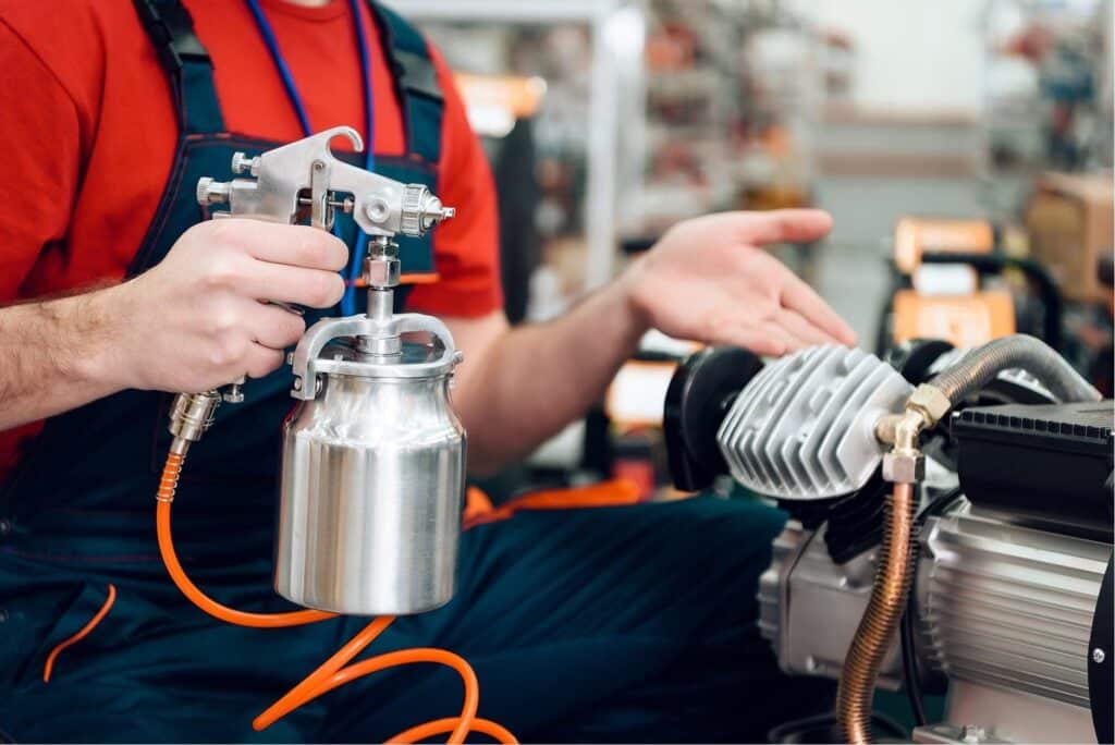 technician holding silent air compressor with wires connected